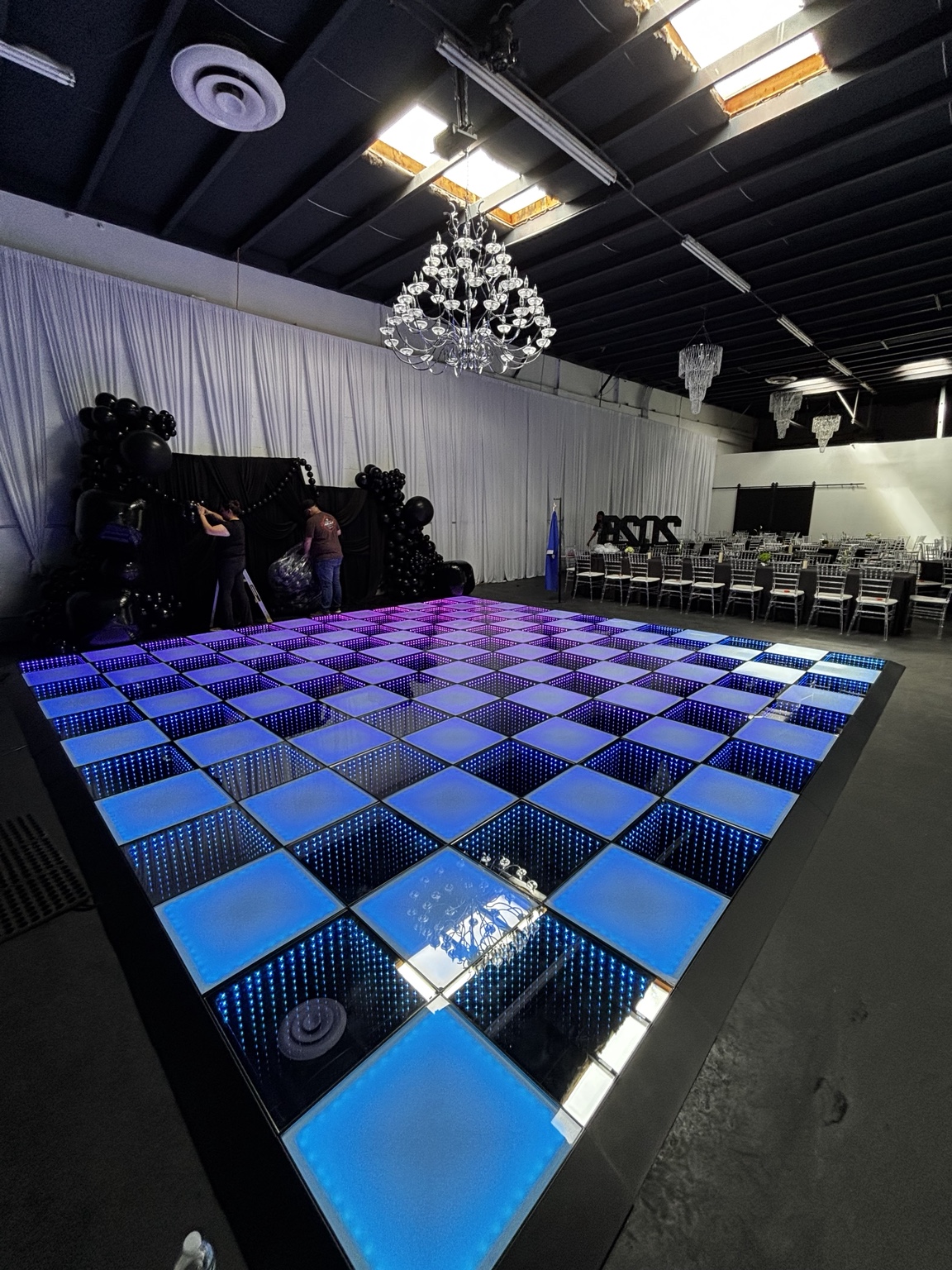 5280 Dance LLC blue and purple infinity dance floor beneath chandeliers